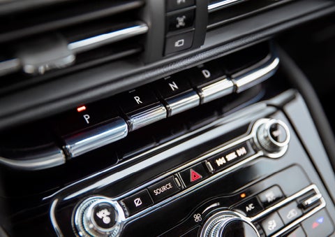 The Park button on the elegant Piano Key Shifter is lit up and engaged as light dances off the chrome accents and horizontal design lines | Bedford Lincoln PA in Bedford PA