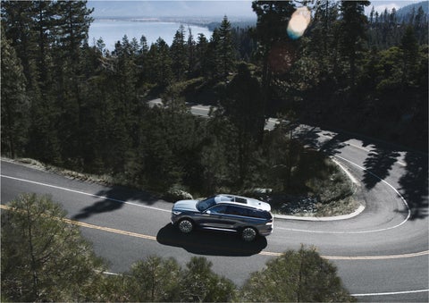 A 2023 Lincoln Aviator® SUV is being driven on a winding mountain road | Bedford Lincoln PA in Bedford PA