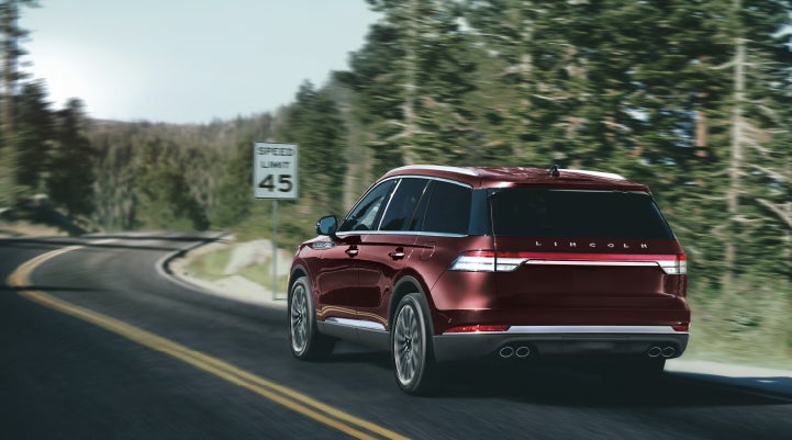 A 2024 Lincoln Aviator® SUV is being driven on a winding mountain road | Bedford Lincoln PA in Bedford PA