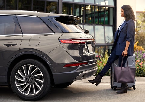 A woman with her hands full uses her foot to activate the available hands-free liftgate. | Bedford Lincoln PA in Bedford PA