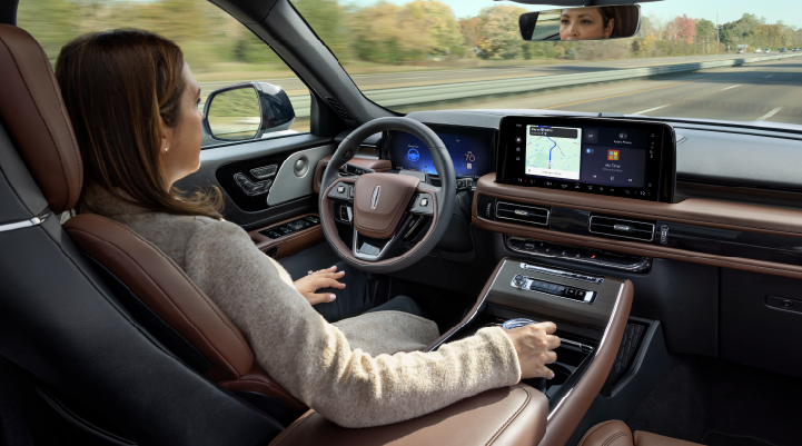 A woman is seen sitting in the driver’s seat of her 2025 Lincoln Aviator® SUV with her hands off the steering wheel. | Bedford Lincoln PA in Bedford PA