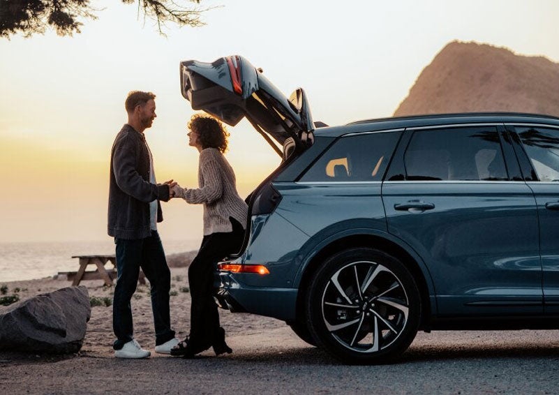 A couple share a moment together outside a 2025 Lincoln Corsair® SUV near the open liftgate. | Bedford Lincoln PA in Bedford PA