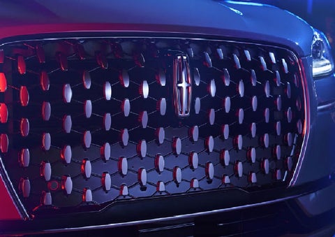 The grille of a 2025 Lincoln Corsair® SUV reflects neon light at night. | Bedford Lincoln PA in Bedford PA