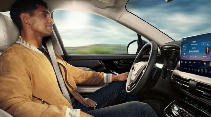 A person is shown using Lincoln BlueCruise hands-free highway driving technology on a divided highway called a Hands-Free Blue Zone. | Bedford Lincoln PA in Bedford PA