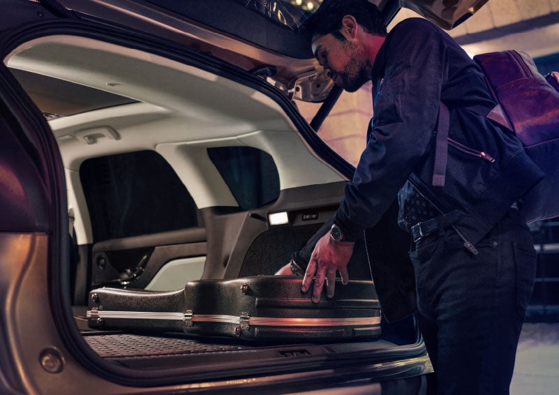 A man is shown loading cargo into the rear of a 2024 Lincoln Corsair® SUV with the second-row seats folded flat. | Bedford Lincoln PA in Bedford PA
