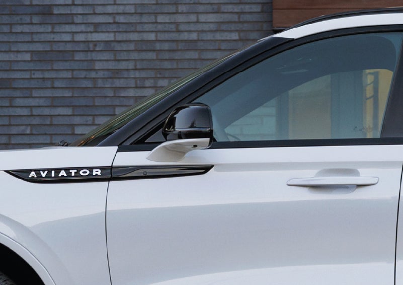 The driver’s side door and fender badging of a white 2026 Lincoln Aviator® SUV are showcased. | Bedford Lincoln PA in Bedford PA