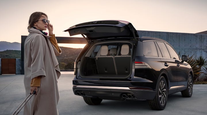 A woman approaches a 2026 Lincoln Aviator® SUV with its rear liftgate open. | Bedford Lincoln PA in Bedford PA