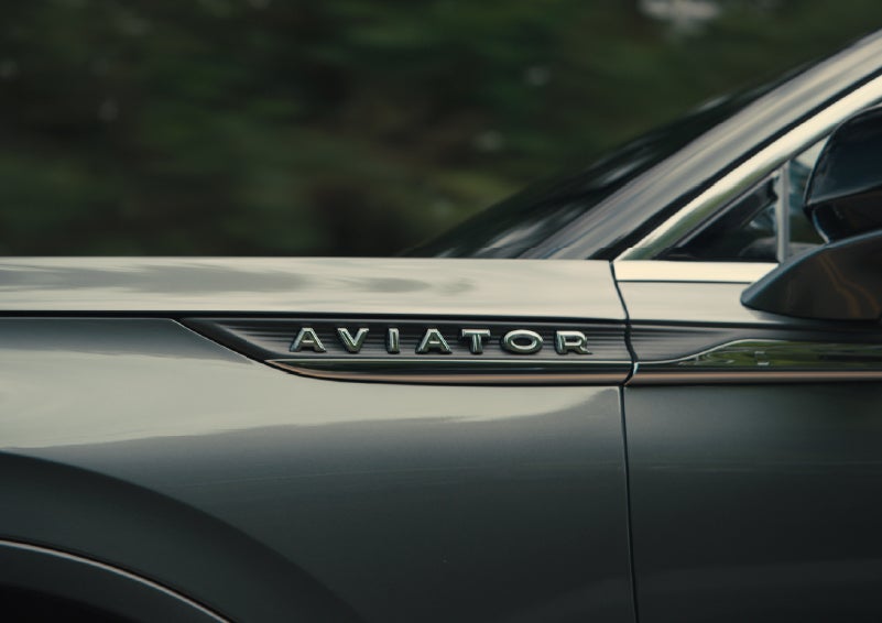 The driver’s side door and fender badging of a gray 2027 Lincoln Aviator® SUV are showcased. | Bedford Lincoln PA in Bedford PA