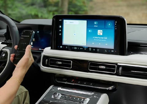 A person pairs thier phone with the center touchscreen of a 2027 Lincoln Aviator® Black Label™ SUV | Bedford Lincoln PA in Bedford PA